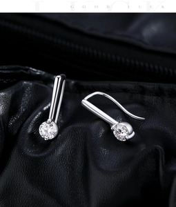 Makroaufnahme von Sterling Silber Ohrringen mit rundem Moissanit auf schwarzem Leder