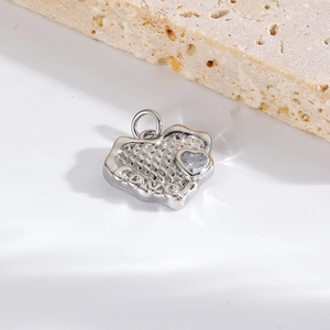 Close-up of a silver heart pendant with LOVE engraving and a clear zircon stone