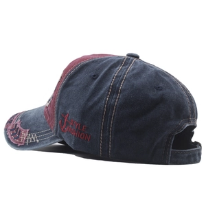 Detail of vintage washed denim baseball cap featuring side anchor embroidery and distressed edges