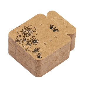 Stack of kraft paper earring display cards with crown and floral patterns on white background