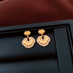 Macro view of 24k gold-plated Ruyi lock earrings with frosted finish and cubic zirconia