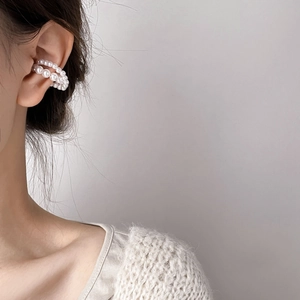 Close-up of double-layered pearl ear cuff featuring a woven white bead design for women