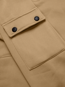 Detail of khaki hoodie pocket featuring a black snap button and knitted fabric texture