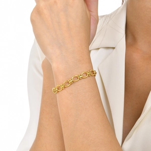 Detail of 18K gold-plated stainless steel Figaro bracelet with gold bead accents on wrist