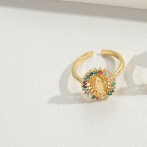 Detail of gold bow ring featuring embossed center and colorful gemstone accents