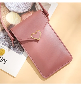Pink crossbody phone bag featuring a gold heart buckle and a slim faux leather strap