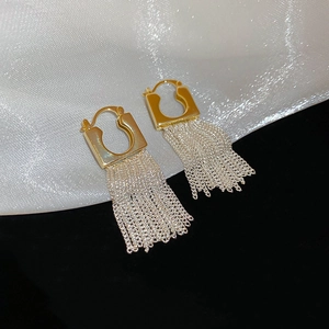 Detail of 14k gold plated U-shaped earrings with dense silver chain tassel pendants