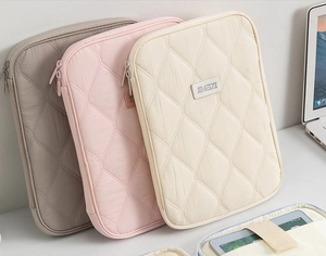 Internal view of quilted tablet sleeve showing protective slots and elastic straps