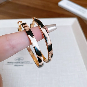 Detail of leopard print hoop earrings with golden inner finish and needle closure