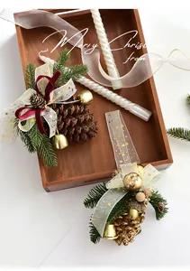 Close-up of Christmas pine cone ornament with golden bells and red velvet bow detail