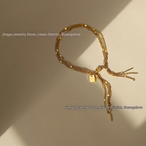 Detailed view of 18K gold plated triple-layer tassel bracelet with a rectangle pendant