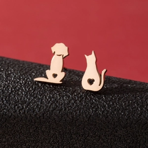 Minimalist rose gold cat and dog stud earrings with hollow heart details on red background