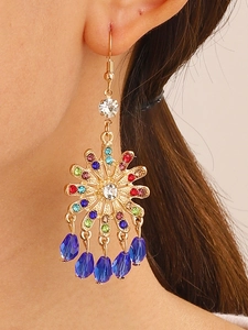 Detail of bohemian sunburst earring with multi-color rhinestones and blue teardrop beads