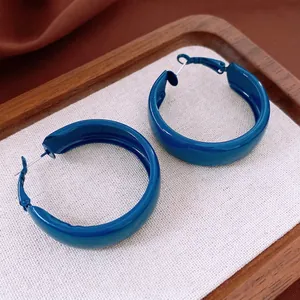 Glossy blue enamel chunky hoop earrings with silver pins shown from a 45-degree angle