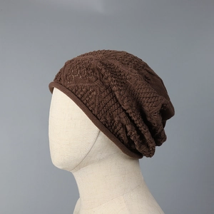 Detailed view of dark brown hollow knit texture and intricate crochet pattern on the hat