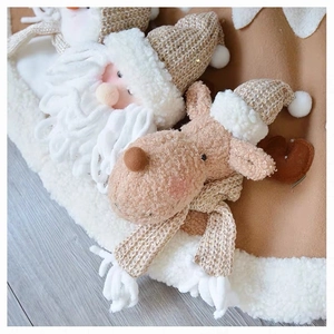 Detail of plush Santa and reindeer figurines on a knit Christmas tree skirt