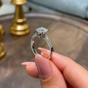 Classic four-prong round zircon engagement ring with micro-paved side stones in silver