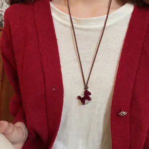 Zircon flocked rocking horse necklace with deep red velvet finish and brown cord