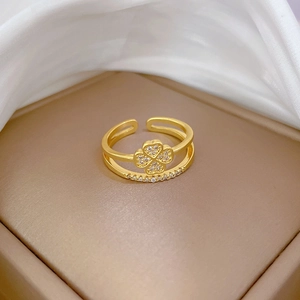 Close-up of gold clover ring with pavé zircons on silk background and jewelry box