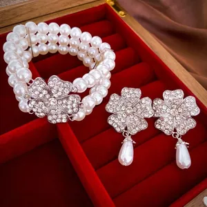 Elegant pearl and rhinestone floral jewelry set with a bracelet and drop earrings