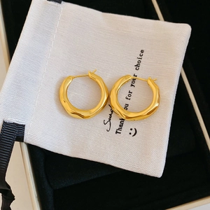 Macro shot of 18K gold-plated hoop earrings with textured finish in elegant packaging