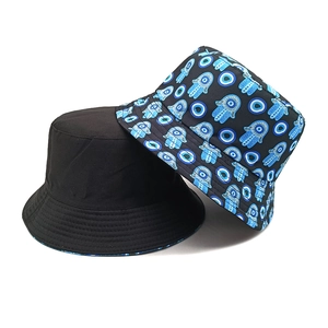 Detail of a black bucket hat and a hat featuring blue Hamsa Hand and Evil Eye prints