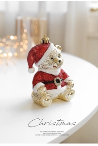 Detail of a golden resin Christmas bear ornament with red glitter hat and warm festive lights