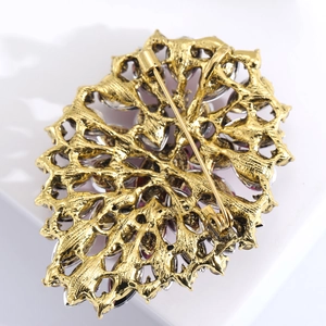 Detailed macro view of the gold alloy brooch back with intricate metalwork and safety pin