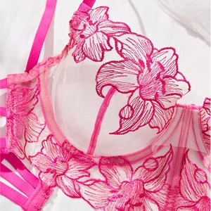 Macro detail of pink floral embroidery on sheer mesh lace bra with vibrant pink straps