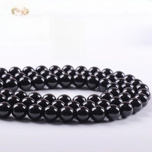 Macro view of polished natural black agate round beads with glossy mirror finish
