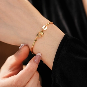 Detailed close-up of 18K gold plated bamboo bracelet with textured diamond pattern orb
