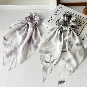 Detailed view of purple and grey marble tie-dye chiffon scrunchies with long streamers