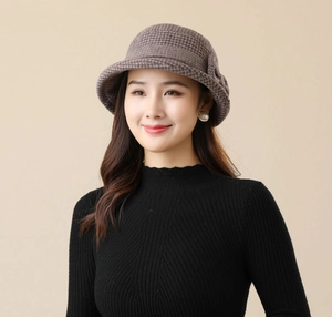Detail of a brown houndstooth cloche hat for women with a rolled brim and vintage texture