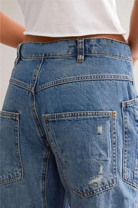 Detailopname van de achterkant en zakken van een vintage blauwe gescheurde bananenjeans
