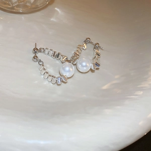 Chic silver geometric chain earrings with elegant white pearl drops on white texture