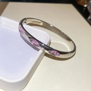 Detail showing pink marquise-cut stones on a polished silver-tone bangle bracelet