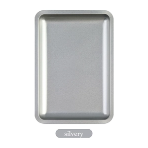Detail view of square silvery stainless steel tray with smooth rounded corners