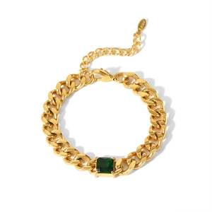 Détail d'un bracelet gourmette plaqué or orné d'une pierre précieuse carrée verte