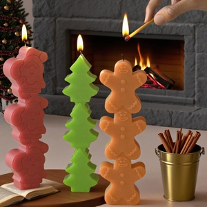 Stacked Christmas scented candles with Santa, tree, and gingerbread man in festive setting