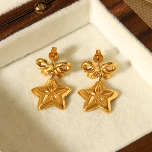 18k gold plated stainless steel bow and star drop earrings on velvet display