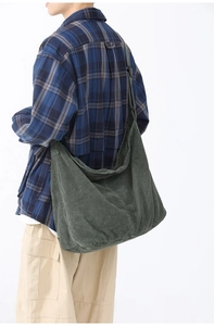 Dark green corduroy tote bag shown on a model with a wide shoulder strap style