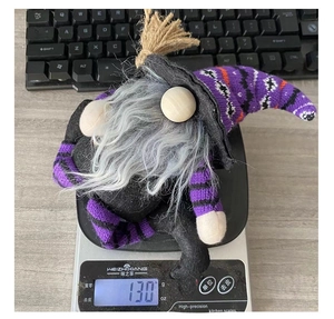 Weight display of Halloween gnome plush toy on scale showing approximately 130 grams