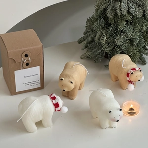Artistic polar bear candles in white and cream with scarves and festive gift box
