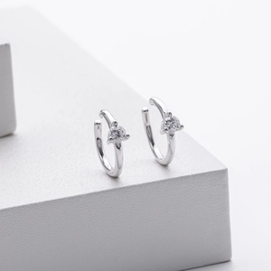 Detail of silver ear cuff with micro-pave round cubic zirconia on white background