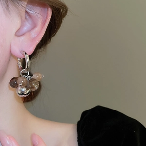 Close-up of model wearing silver resin bead earrings in gradient brown tones