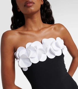 Close-up of 3D white floral applique on a black one-shoulder monokini swimsuit