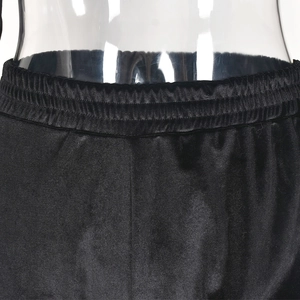 Dettaglio macro della vita alta elastica su pantaloni in velluto nero con trama liscia