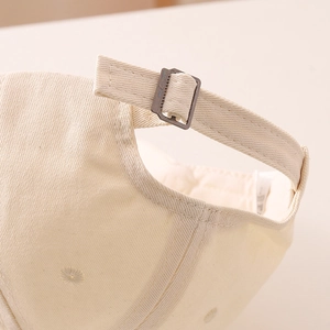 Détail de la boucle en métal réglable et texture en coton sur la casquette enfant