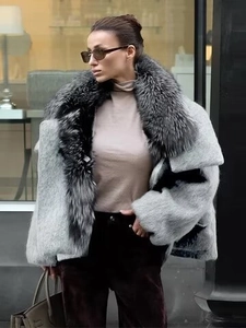 Detailed view of luxury gray faux fur coat with a thick collar on a stylish street model