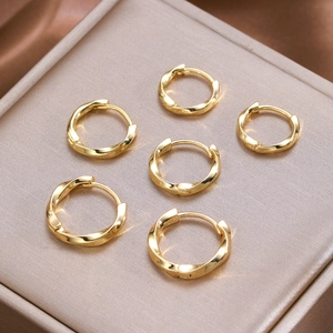 Detail of six-piece set of gold twisted hoop earrings arranged on a premium jewelry box